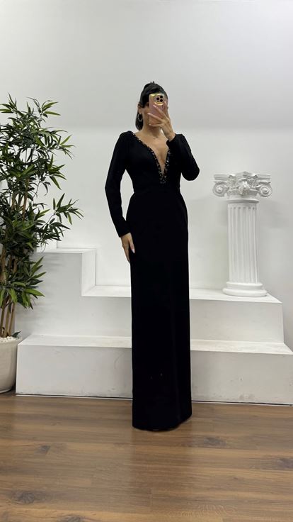 Schwarzes, tief eingefasstes, mit Steinen verziertes Abendkleid in besonderem Design